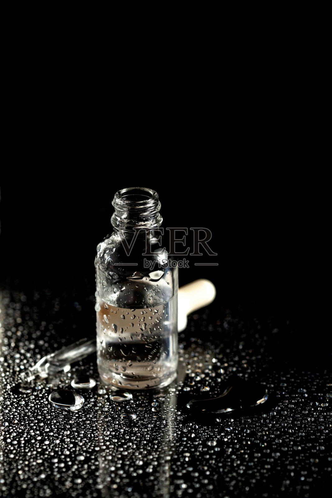 血清瓶与药物滴管在黑色背景照片摄影图片