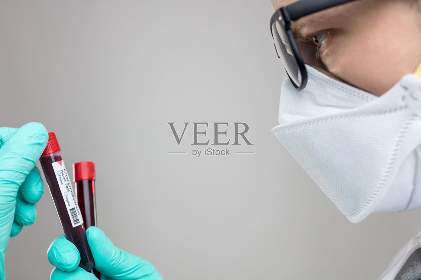 戴呼吸面罩的医生拿着冠状病毒血样照片摄影图片