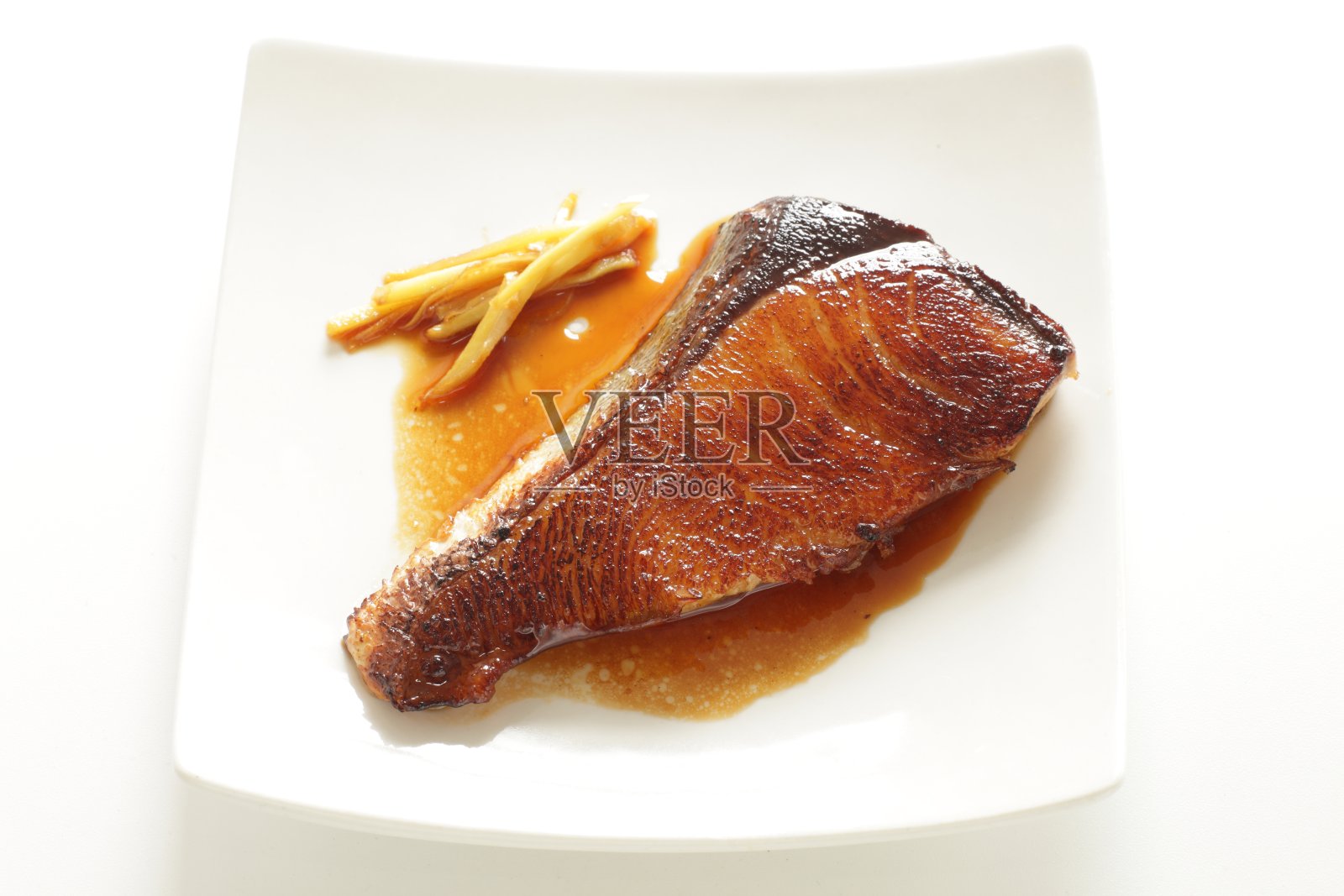 用平底锅煎炸日本黄尾鱼和酱油姜照片摄影图片