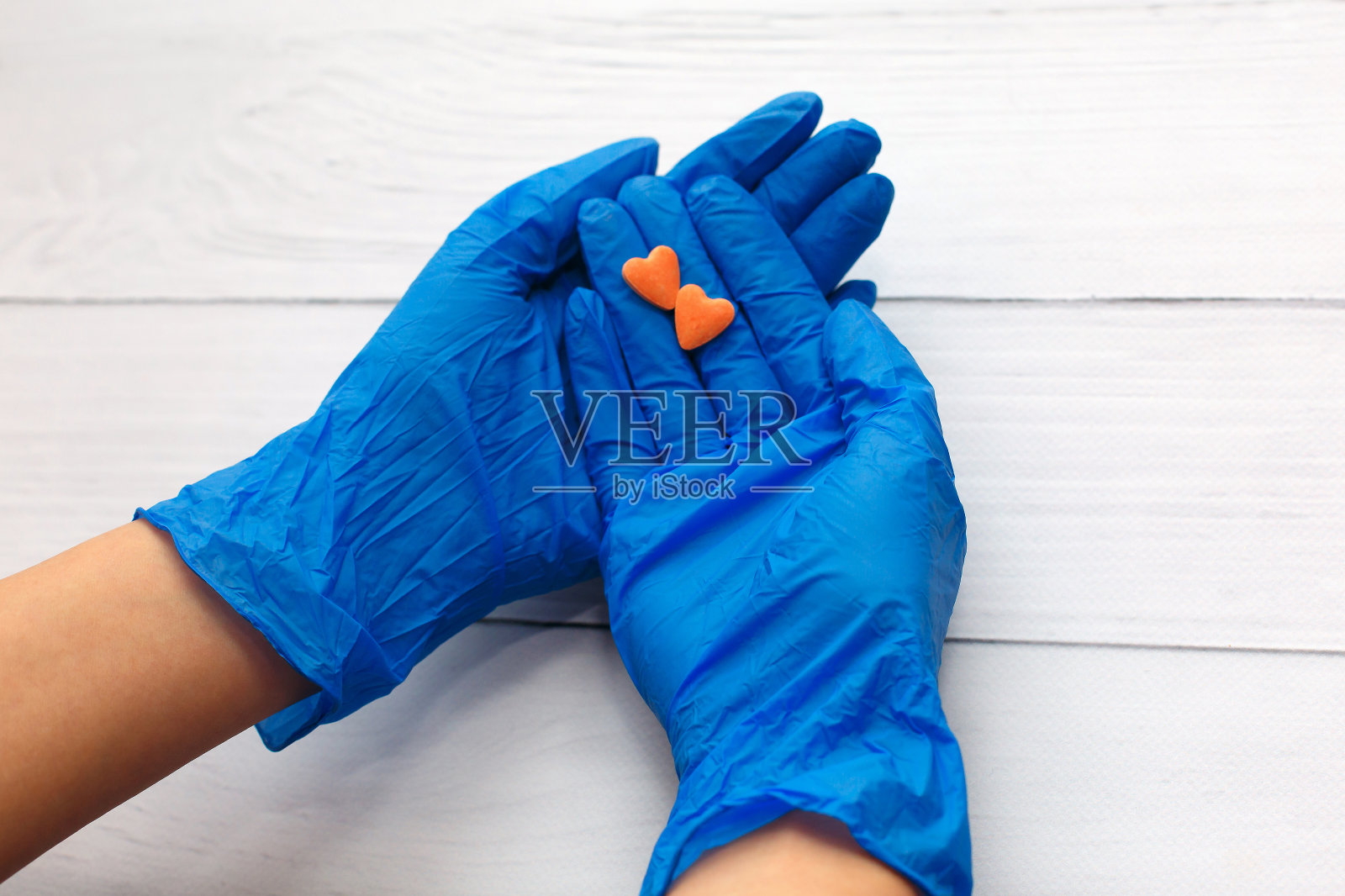 医生的手上拿着蓝色的医用手套，拿着药品、药丸。手上有药。照片摄影图片