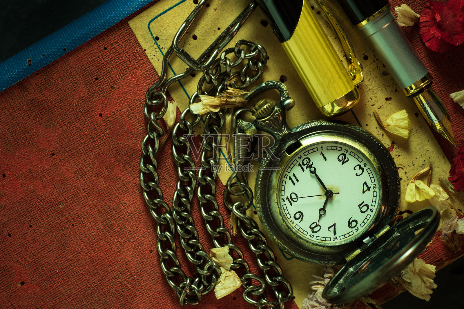 古董怀表和黄铜笔在旧书。照片摄影图片