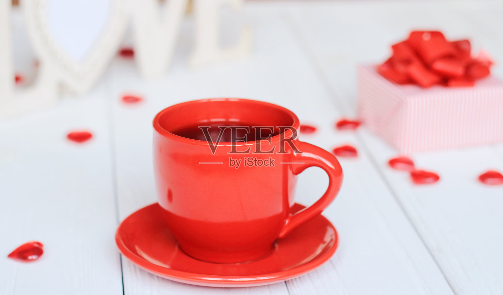 模糊背景上的一杯咖啡和礼物。照片摄影图片