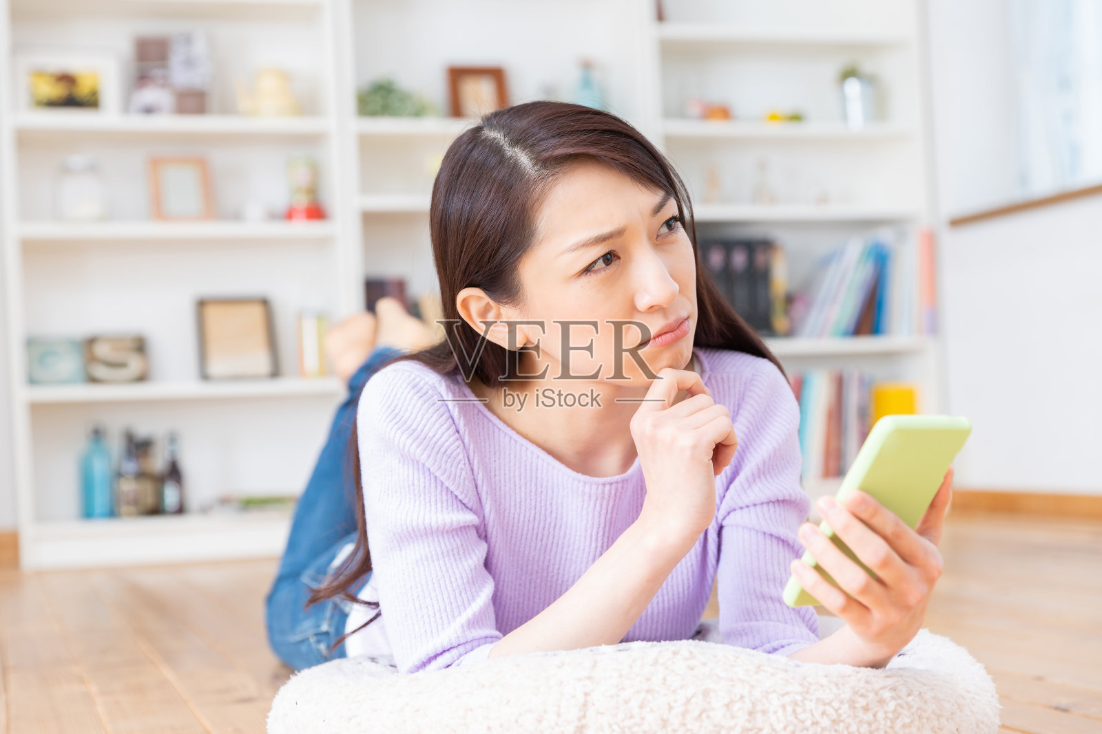 看智能手机的亚洲女人，思考照片摄影图片