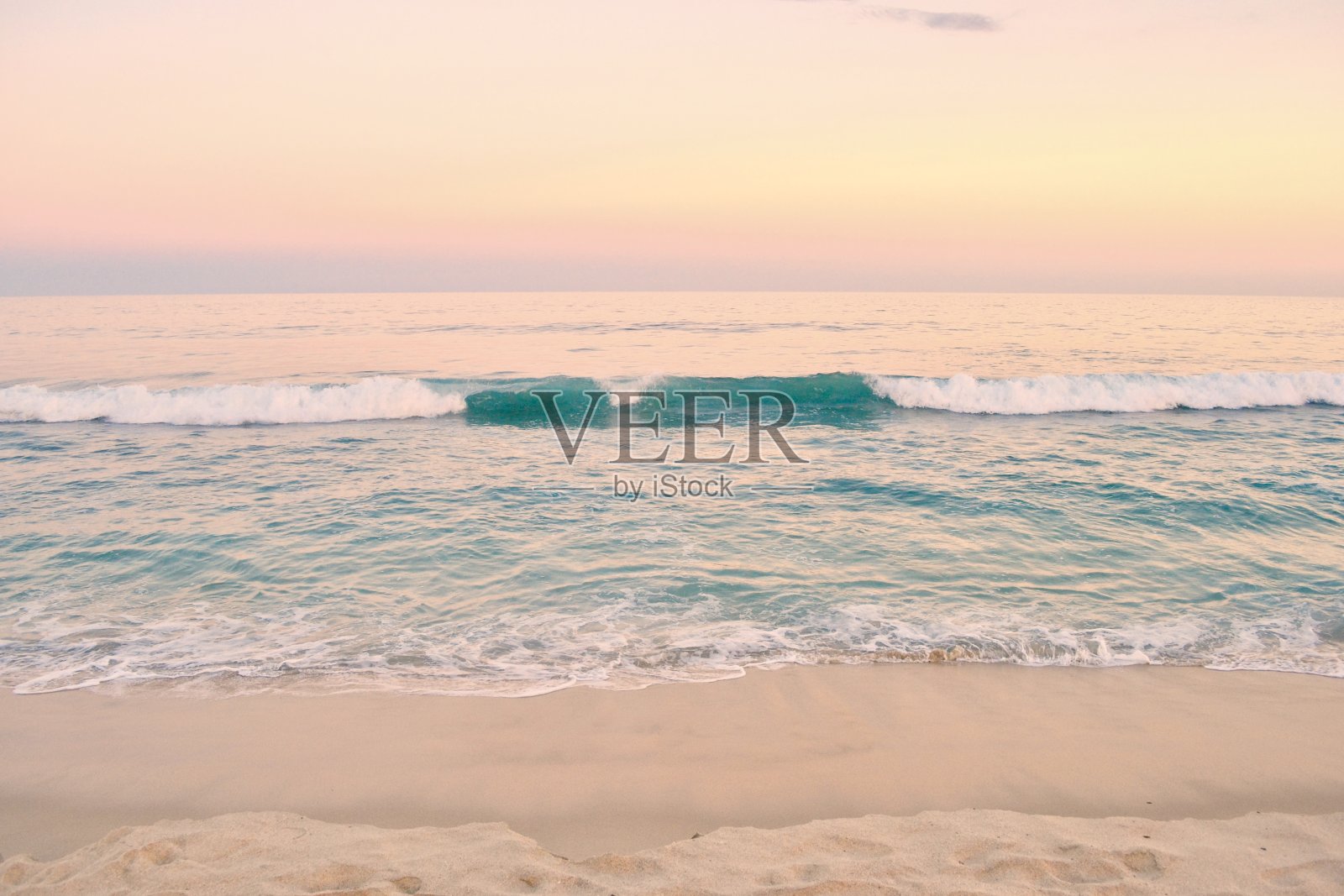 海滩日落与绿松石的波浪照片摄影图片