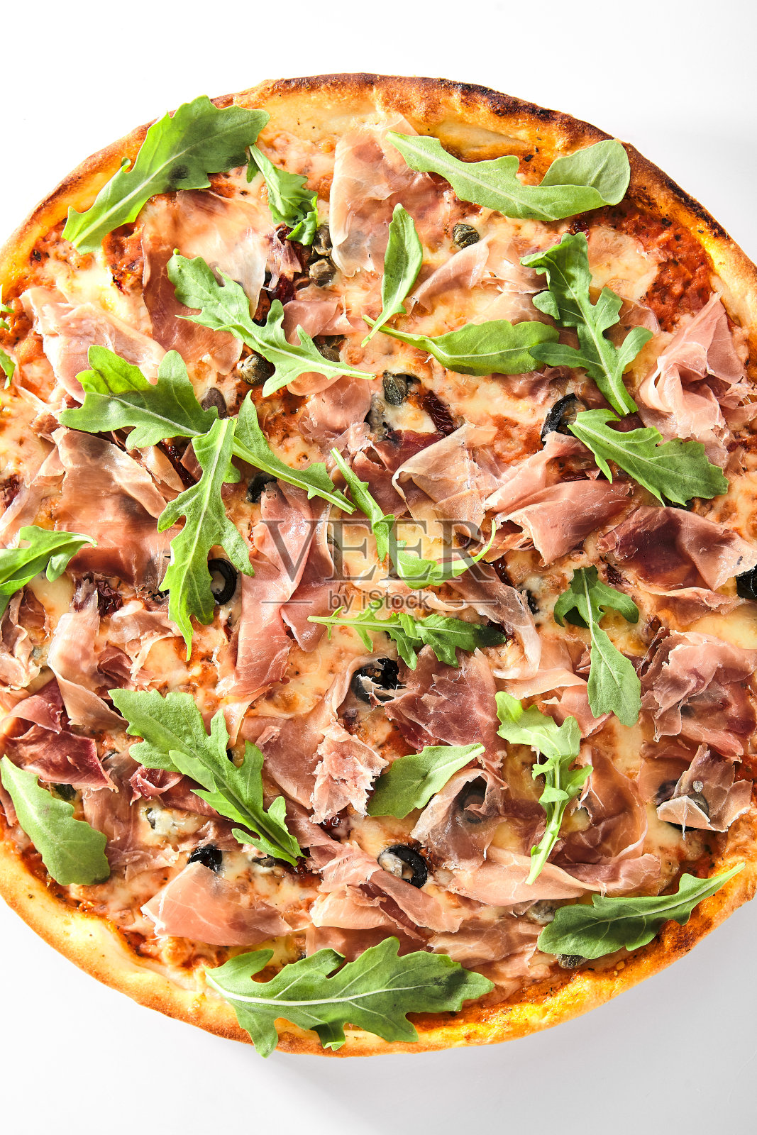 番茄干，刺山柑，意大利熏火腿，芝麻菜和马苏里拉披萨照片摄影图片