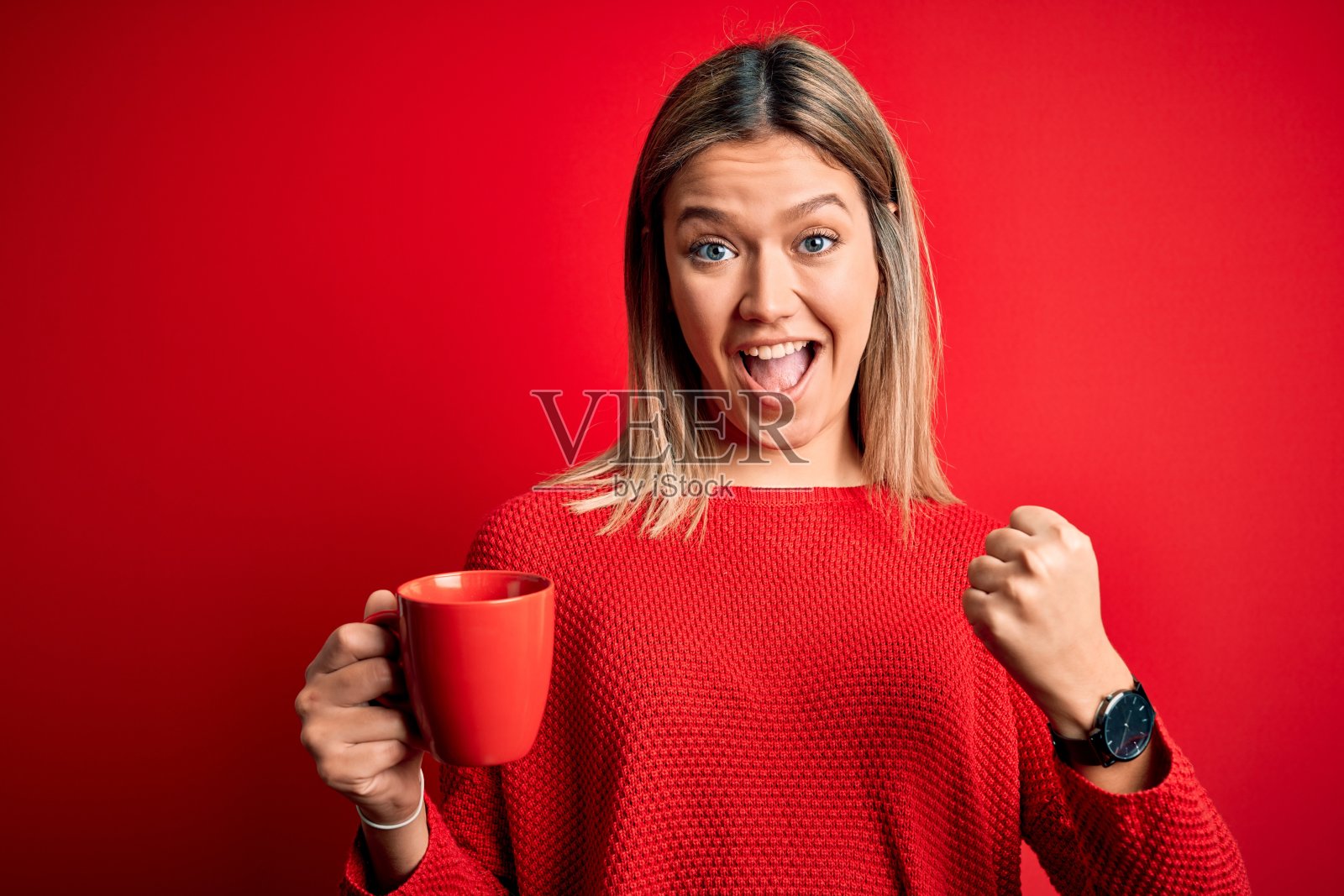 年轻美丽的女子喝着咖啡站在孤立的红色背景下尖叫自豪，庆祝胜利和成功非常兴奋，欢呼的情绪照片摄影图片