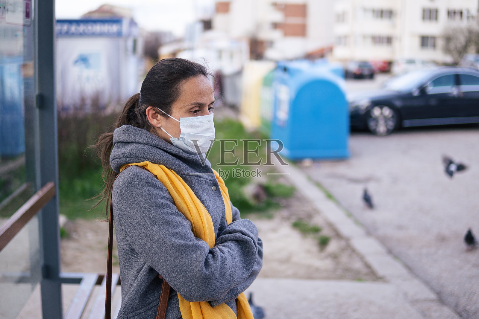 新冠病毒防护。在工作日结束后，城市里的年轻女子戴着防护口罩。思考着即将来临的危险照片摄影图片