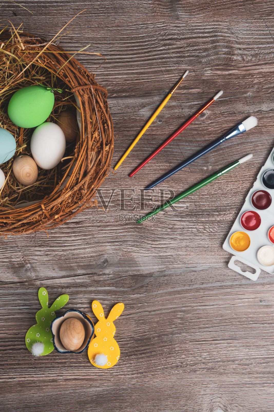 复活节彩蛋和彩色的颜料和画笔，小兔子照片摄影图片
