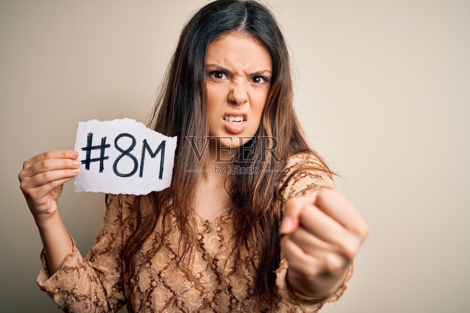年轻美丽的黑发女人庆祝3月8日妇女节在白色的背景，生气和沮丧的呼喊与愤怒，疯狂的呼喊与举起手，愤怒的概念照片摄影图片