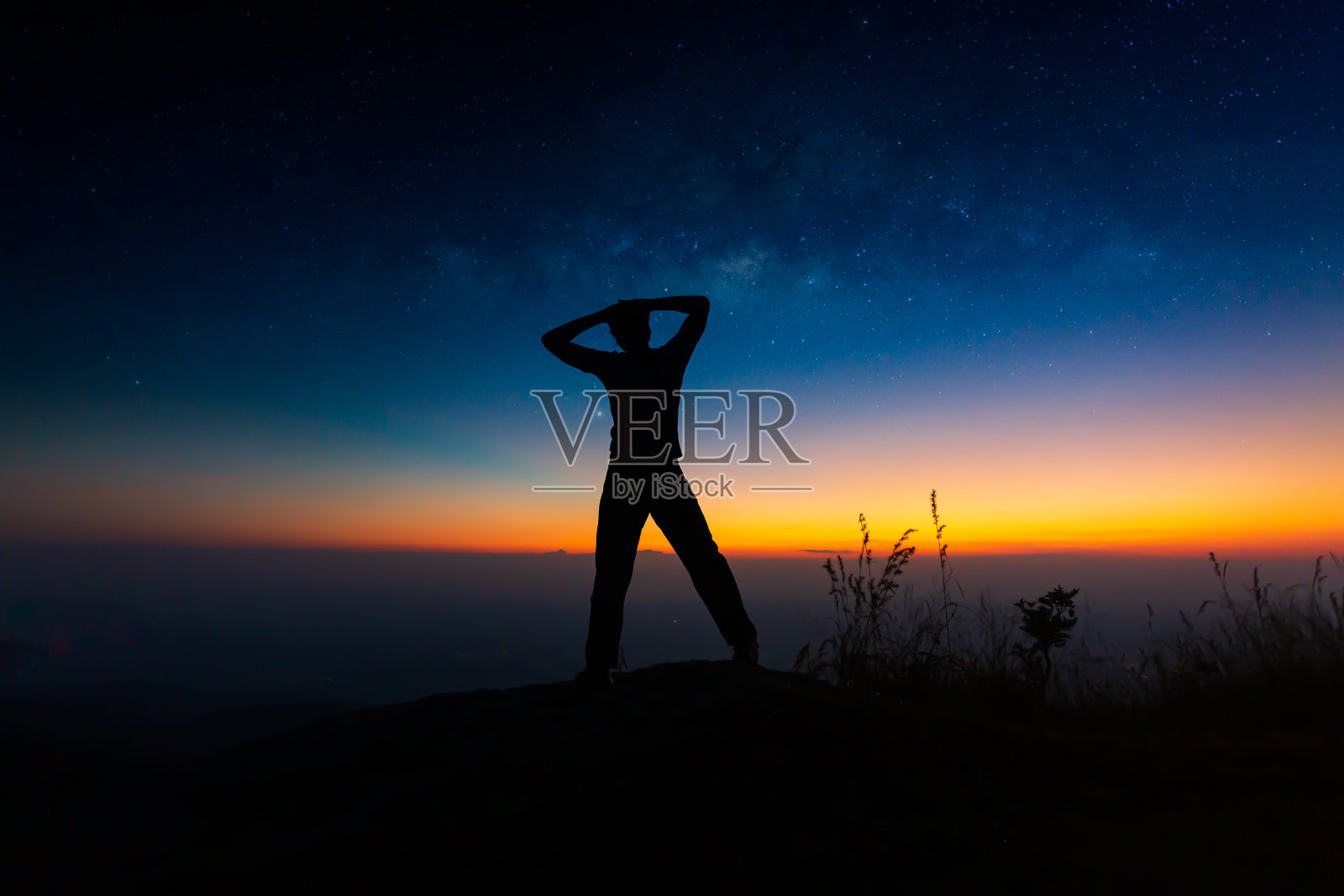 银河系。夜空和一个站立的人的剪影照片摄影图片