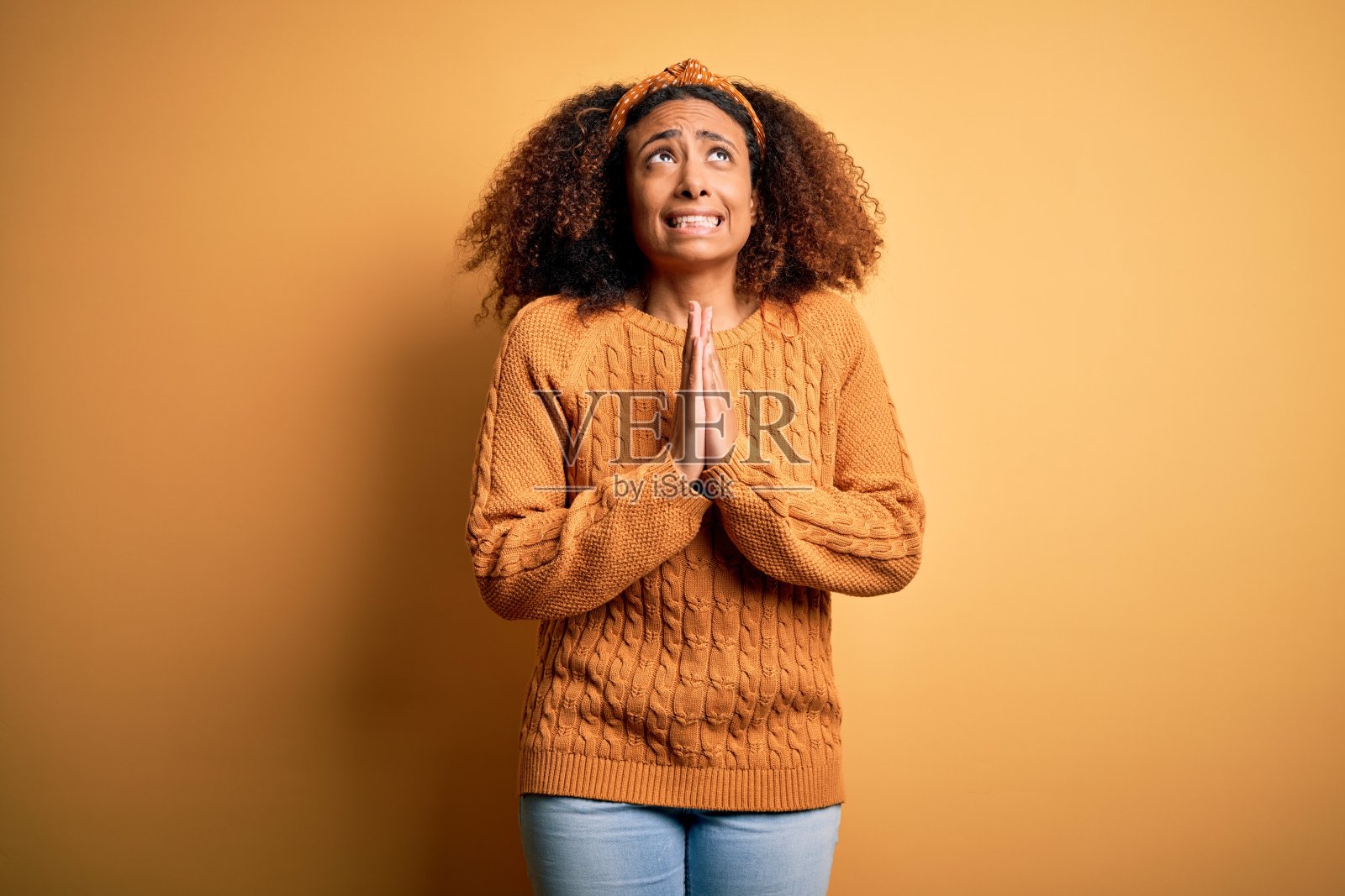 穿着休闲毛衣的非洲裔年轻女性祈祷照片摄影图片