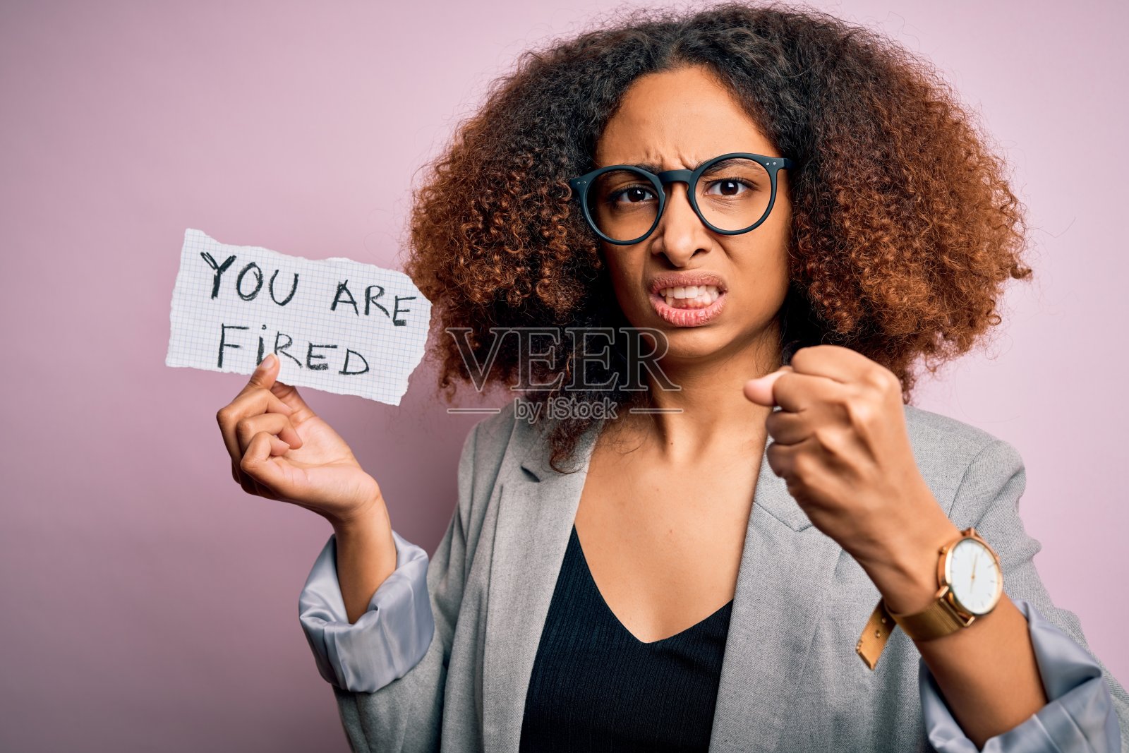 年轻的非洲裔美国女人留着非洲式发型拿着纸和你一起被解雇的信息生气，沮丧，愤怒地大喊大叫，疯狂地举起手大喊大叫，愤怒的概念照片摄影图片