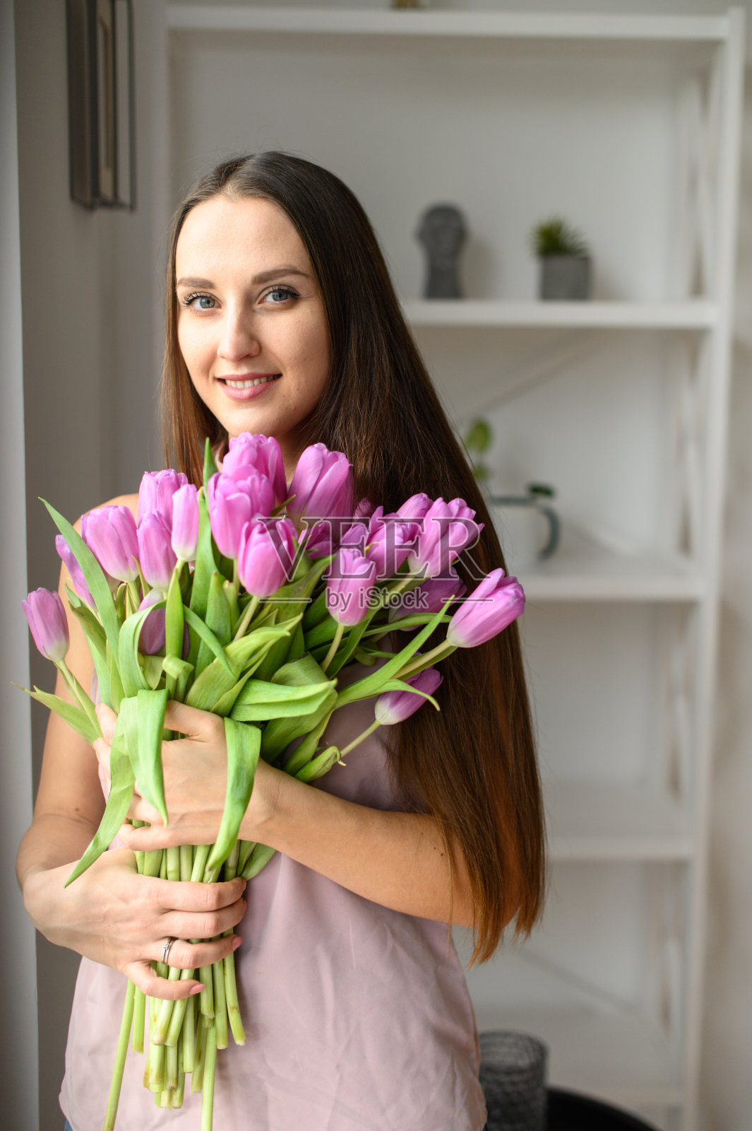 室内手捧郁金香的美丽女人春日氛围照片摄影图片