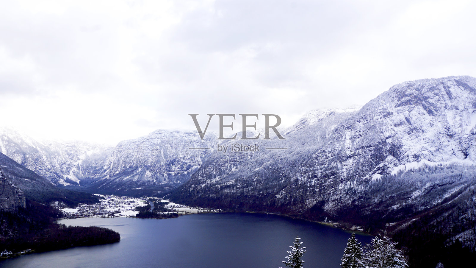 冬季雪山景观山谷和湖泊穿过高地山谷的森林，通往奥地利哈尔斯塔特的老盐矿照片摄影图片