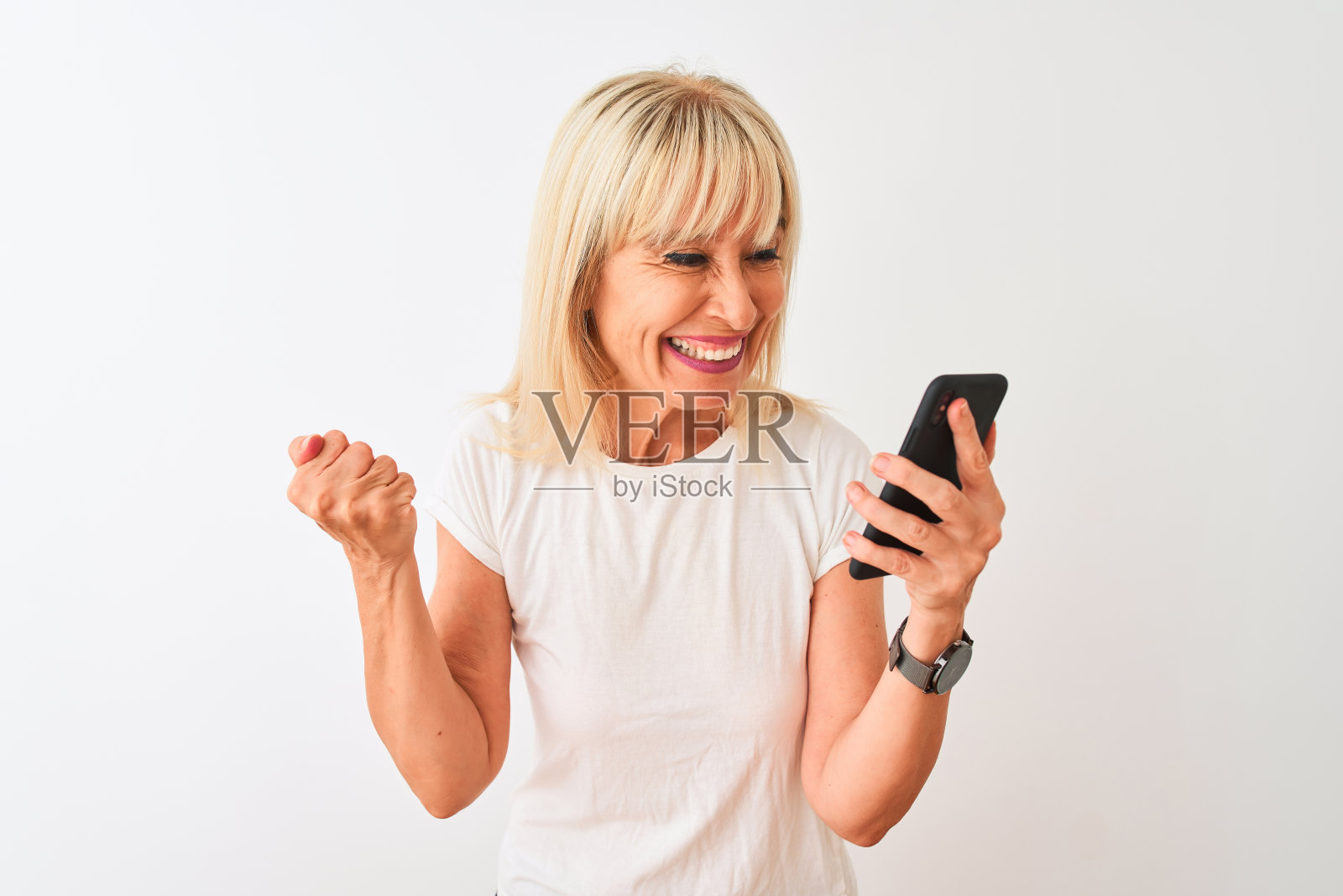 中年妇女用智能手机，自豪地尖叫，庆祝胜利照片摄影图片