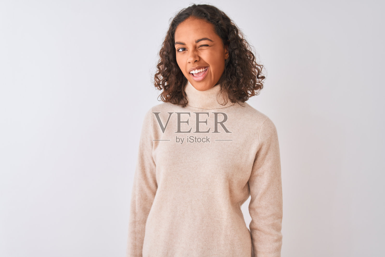 穿着高领毛衣的年轻巴西女性，在白色背景前眨眼照片摄影图片