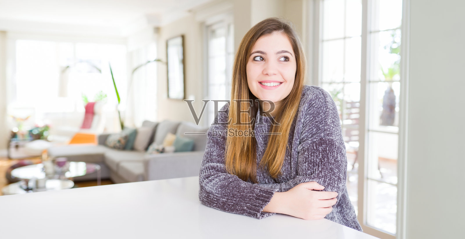 年轻女子在家中微笑，若有所思照片摄影图片