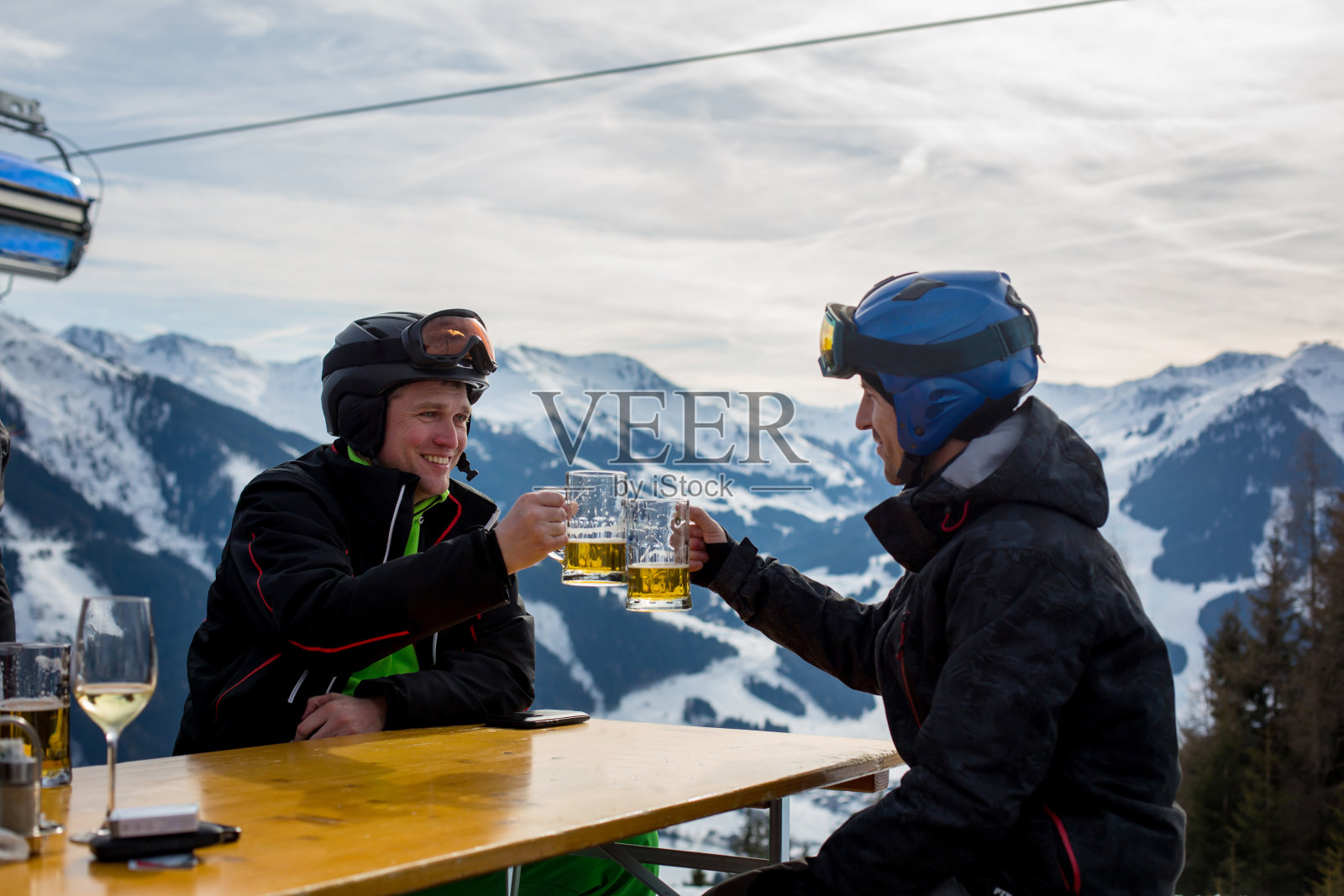 滑雪休息期间，中年男人们在餐厅喝啤酒照片摄影图片
