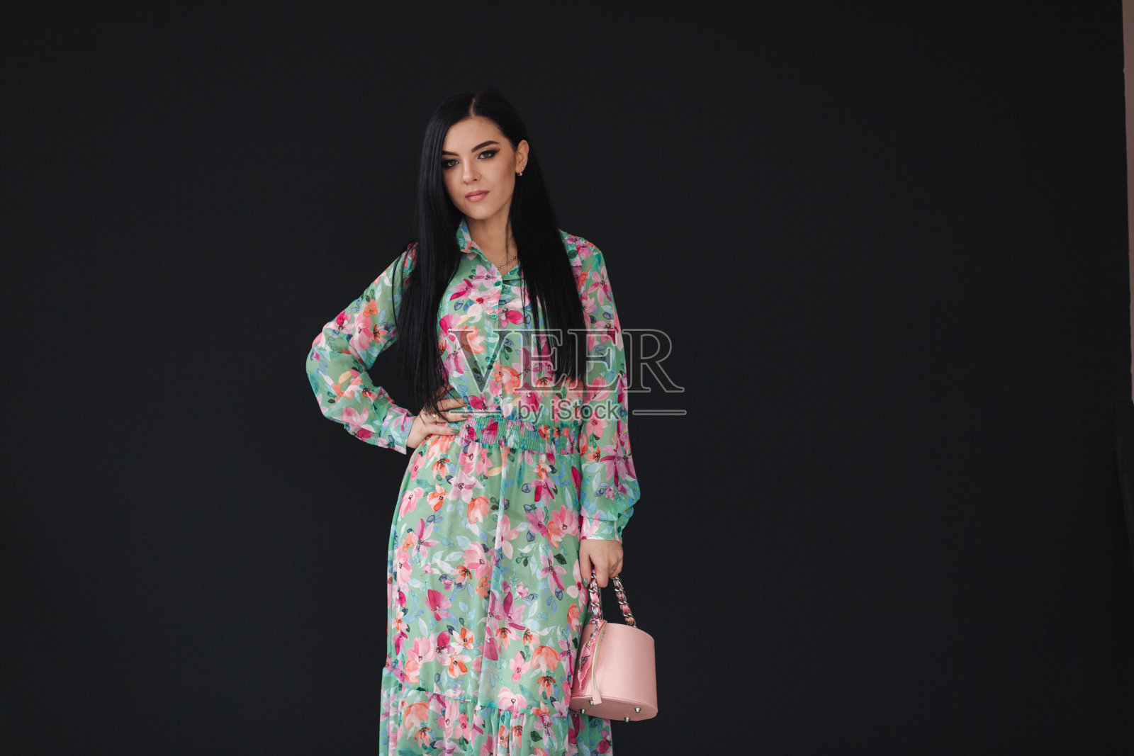 年轻女子模特在黑色背景上展示衣服。美丽的春天的衣服照片摄影图片