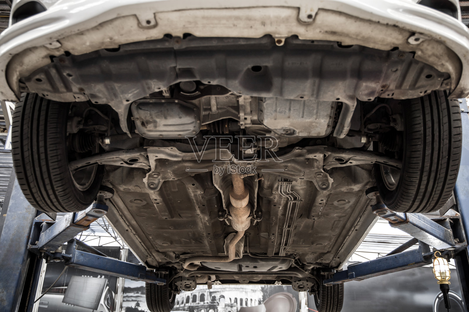 轿车在服务站等修车吊车悬架。照片摄影图片