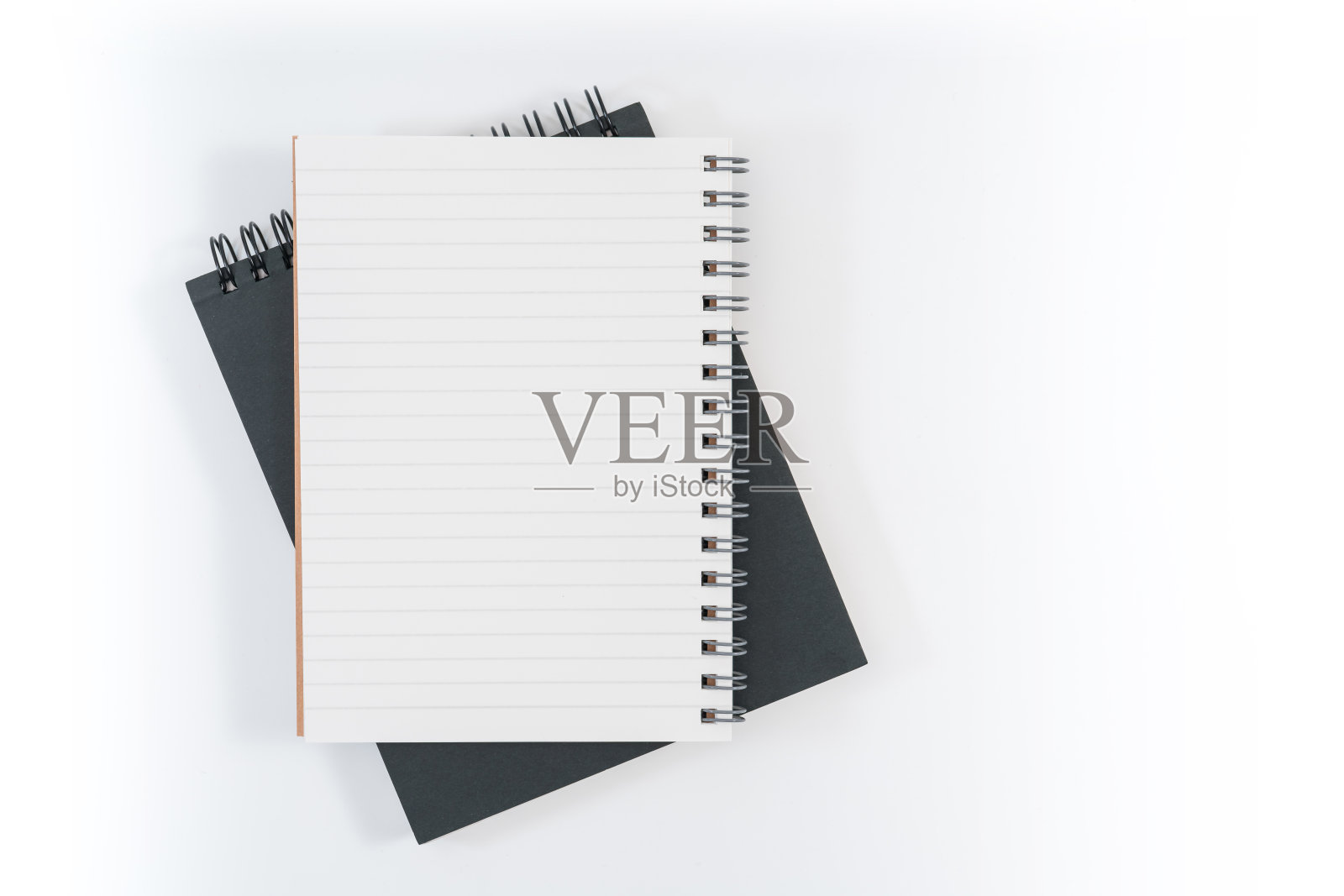 学校的笔记本在蓝色的背景上，螺旋笔记本在桌子上照片摄影图片