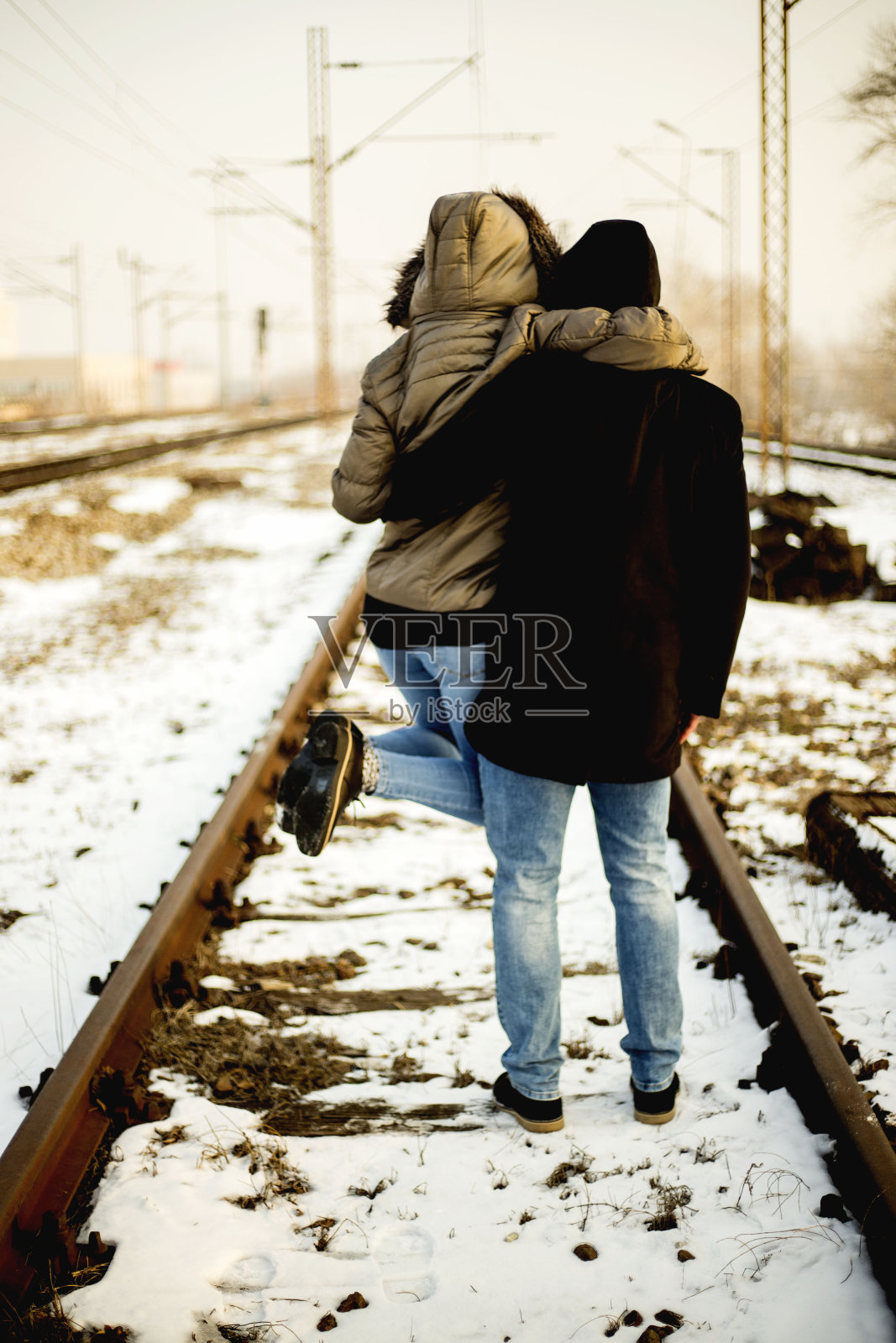 一对年轻夫妇沿着铁轨走向一个未知的目的地照片摄影图片