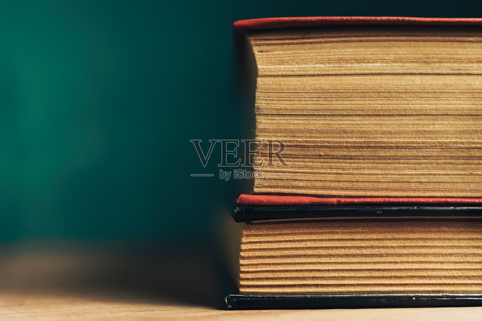 近距离观看美丽的古书。图案背景设计。书放在红色的木桌和绿色的墙壁上。照片摄影图片