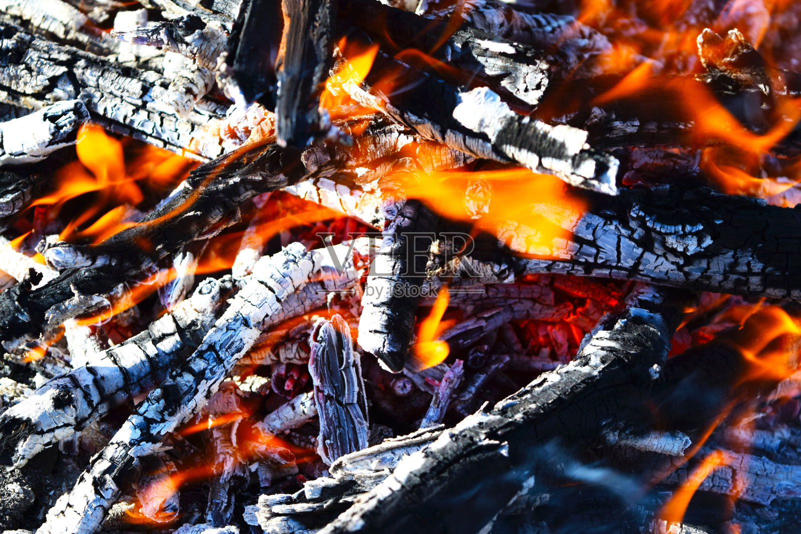 火焰冒烟，炽热的煤火。热煤的火盆。照片摄影图片