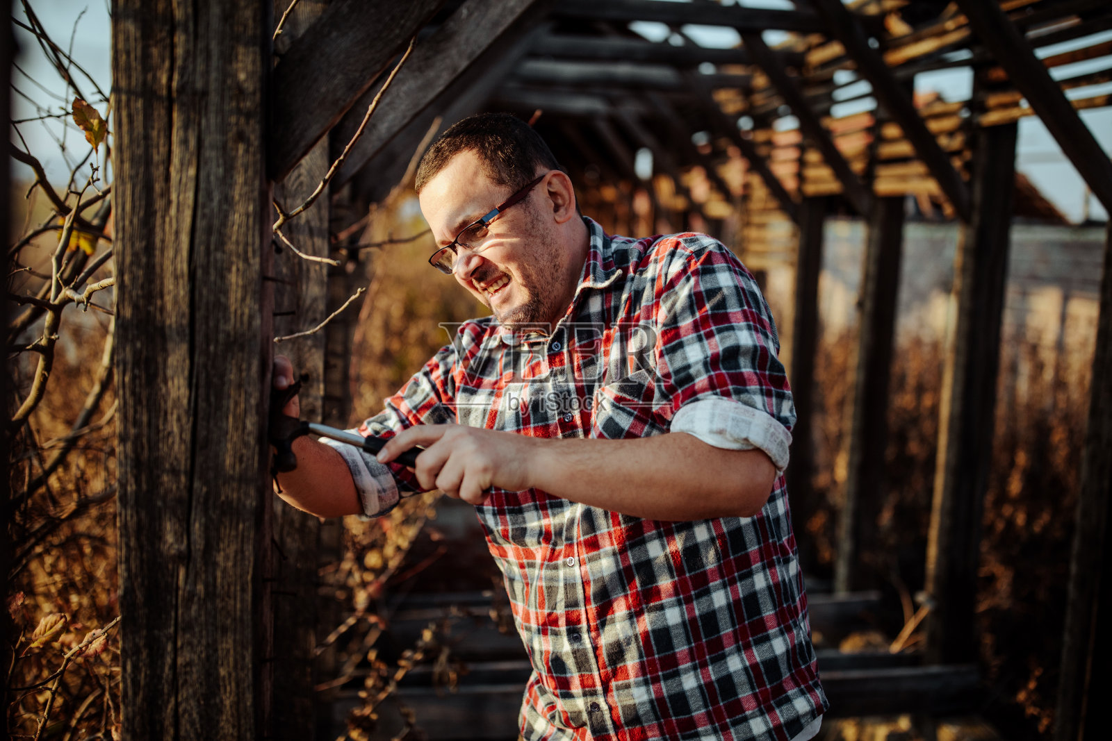 男子在户外修理木制建筑照片摄影图片