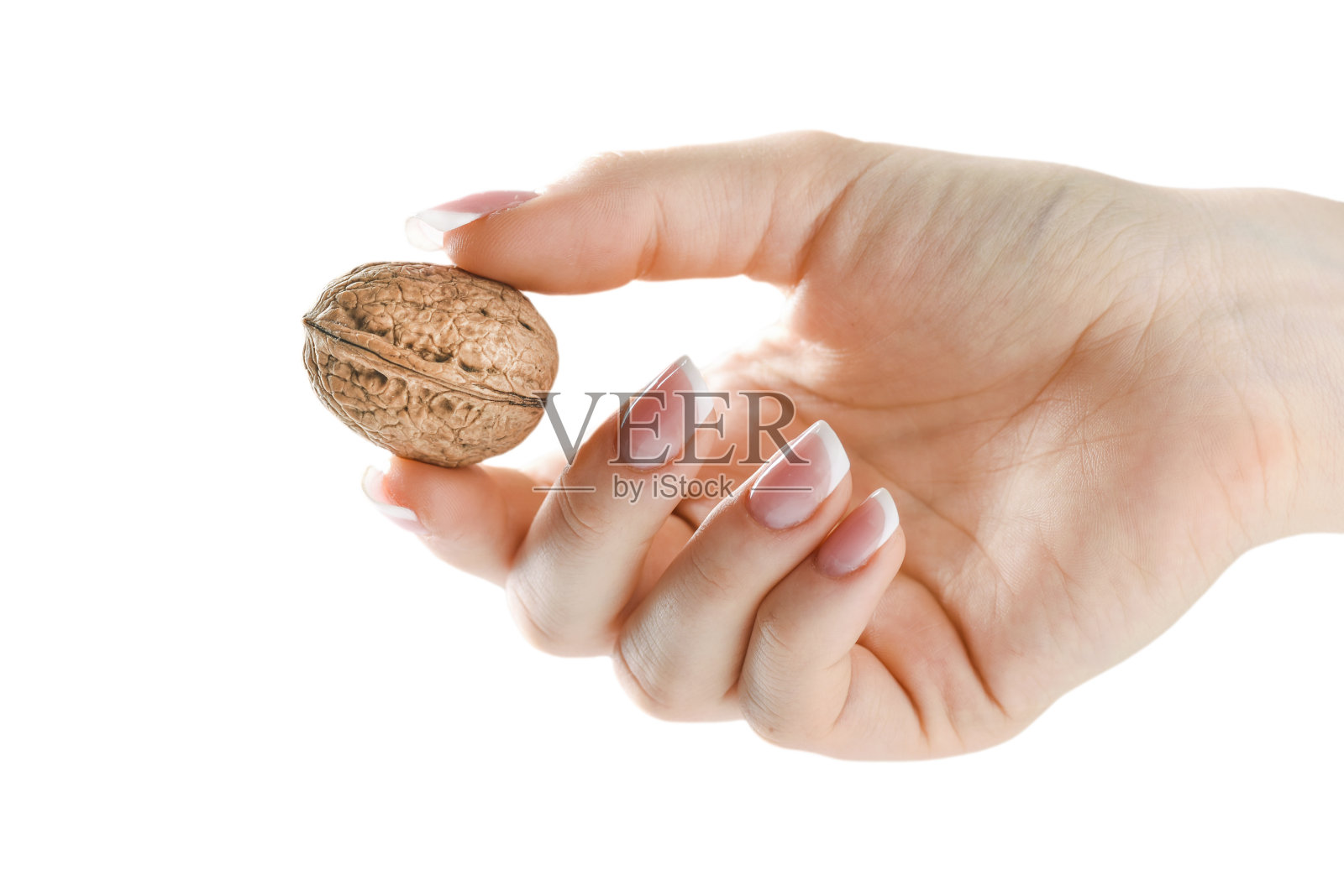 整个核桃放在木碗里，放在女人手上，白底或孤立。照片摄影图片