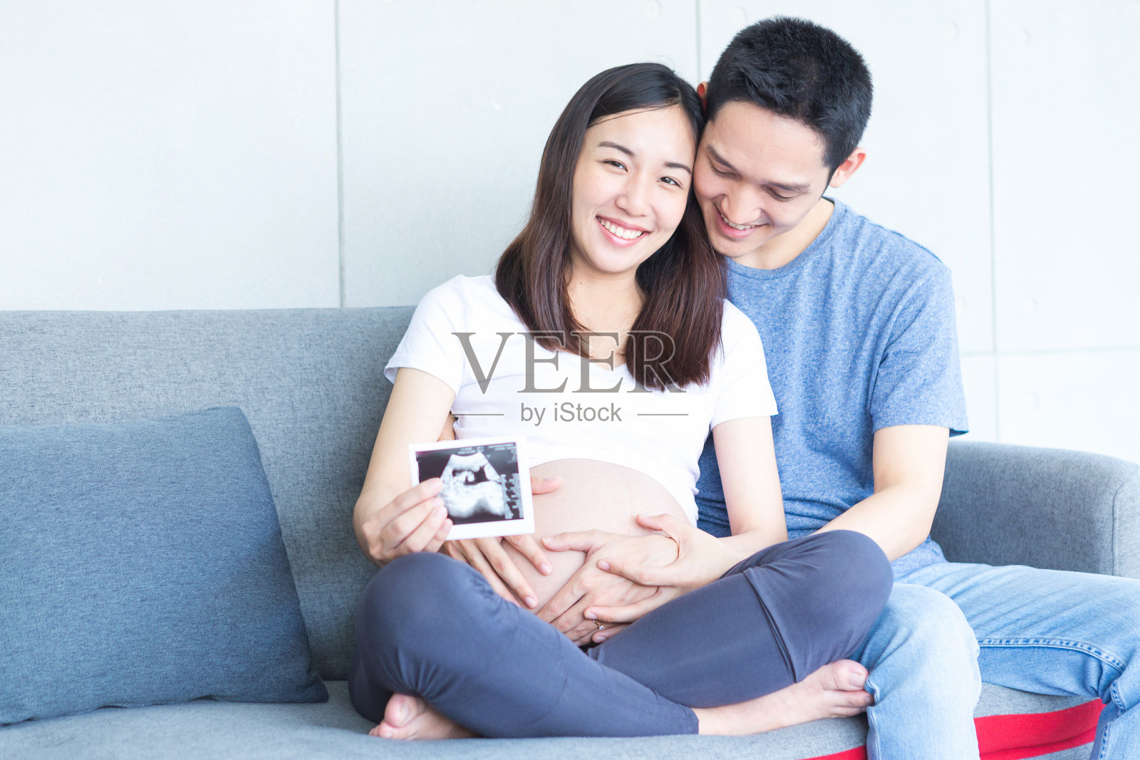 父母展示宝宝的超声波照片，幸福微笑迎接新生儿照片摄影图片