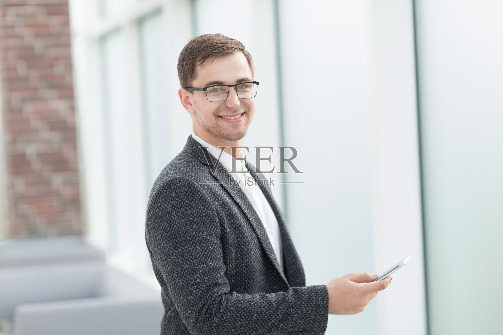 在明亮办公室里使用智能手机的商人照片摄影图片