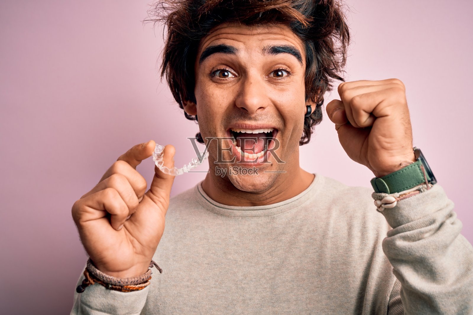 年轻英俊的男子抱着队列站在孤立的粉红色背景尖叫自豪，庆祝胜利和成功非常兴奋，欢呼的情绪照片摄影图片