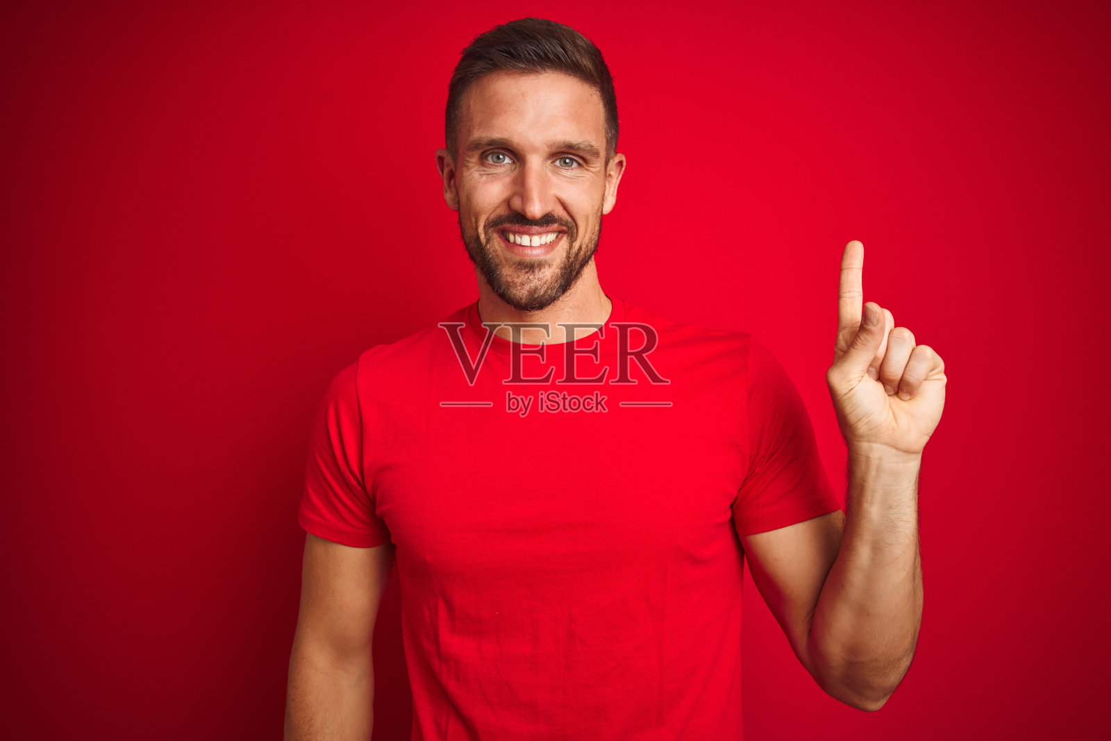 面带微笑指向侧面的年轻男人照片摄影图片