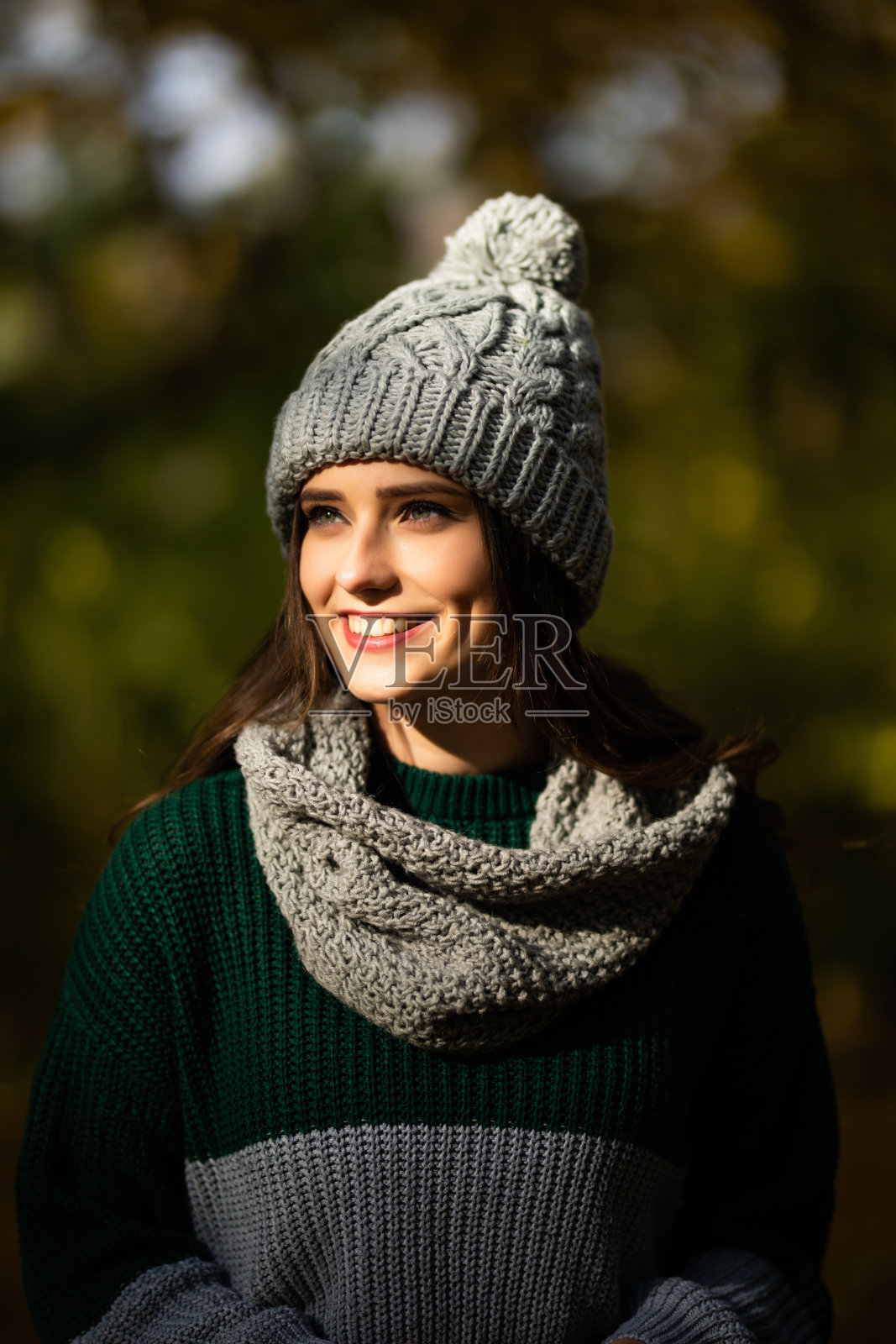 美丽的年轻女子的肖像在针织无檐帽和围巾秋天在公园。照片摄影图片