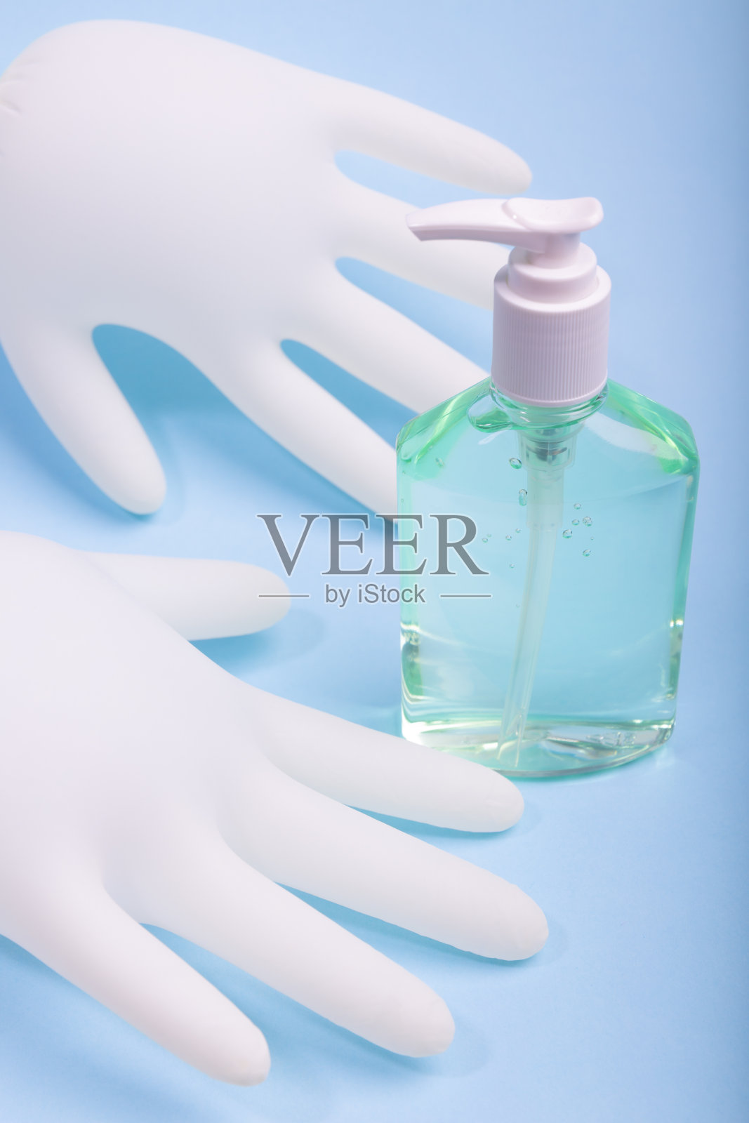 一瓶酒精洗手液和一双医用乳胶手套照片摄影图片