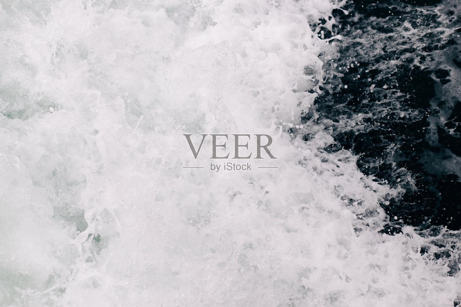 海浪拍打在岩石上产生的沸腾的海水泡沫。自然海背景照片摄影图片