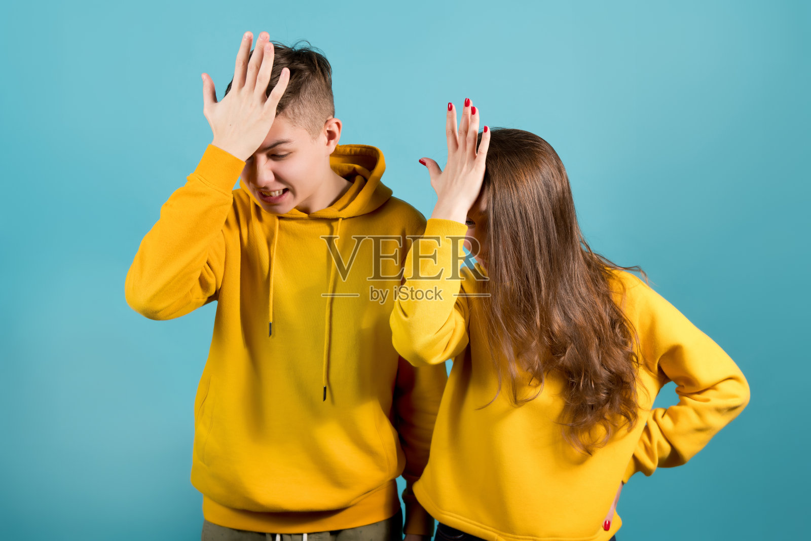 穿黄色连帽衫的兄妹捂脸照片摄影图片