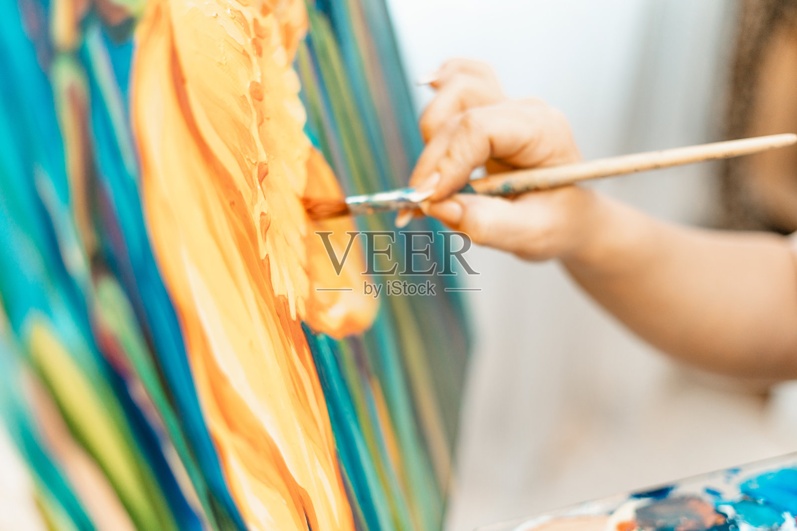艺术，艺术家的作品。年轻美丽的女孩艺术家画了一幅画。艺术家的工作室。创造的过程。绘画和绘画。艺术家的清单。特写镜头。照片摄影图片