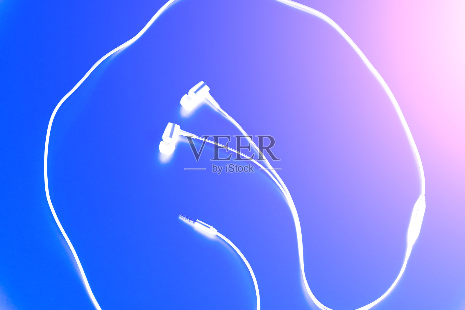 耳机躺在粉红色的背景上。现代音乐的概念。音频技术。照片摄影图片