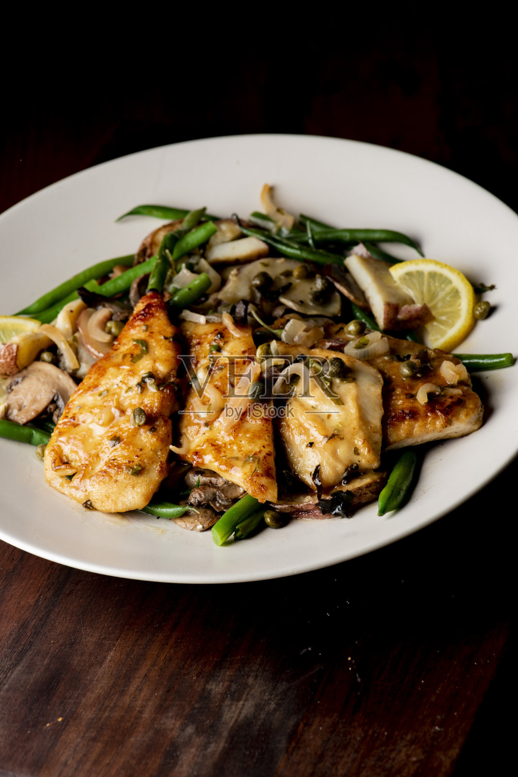 鸡胸肉或比卡塔鸡，用平底锅煎至金黄酥脆，配以农场新鲜的有机蔬菜:胡萝卜、抱子甘蓝和青豆。经典美国餐厅的最爱。照片摄影图片