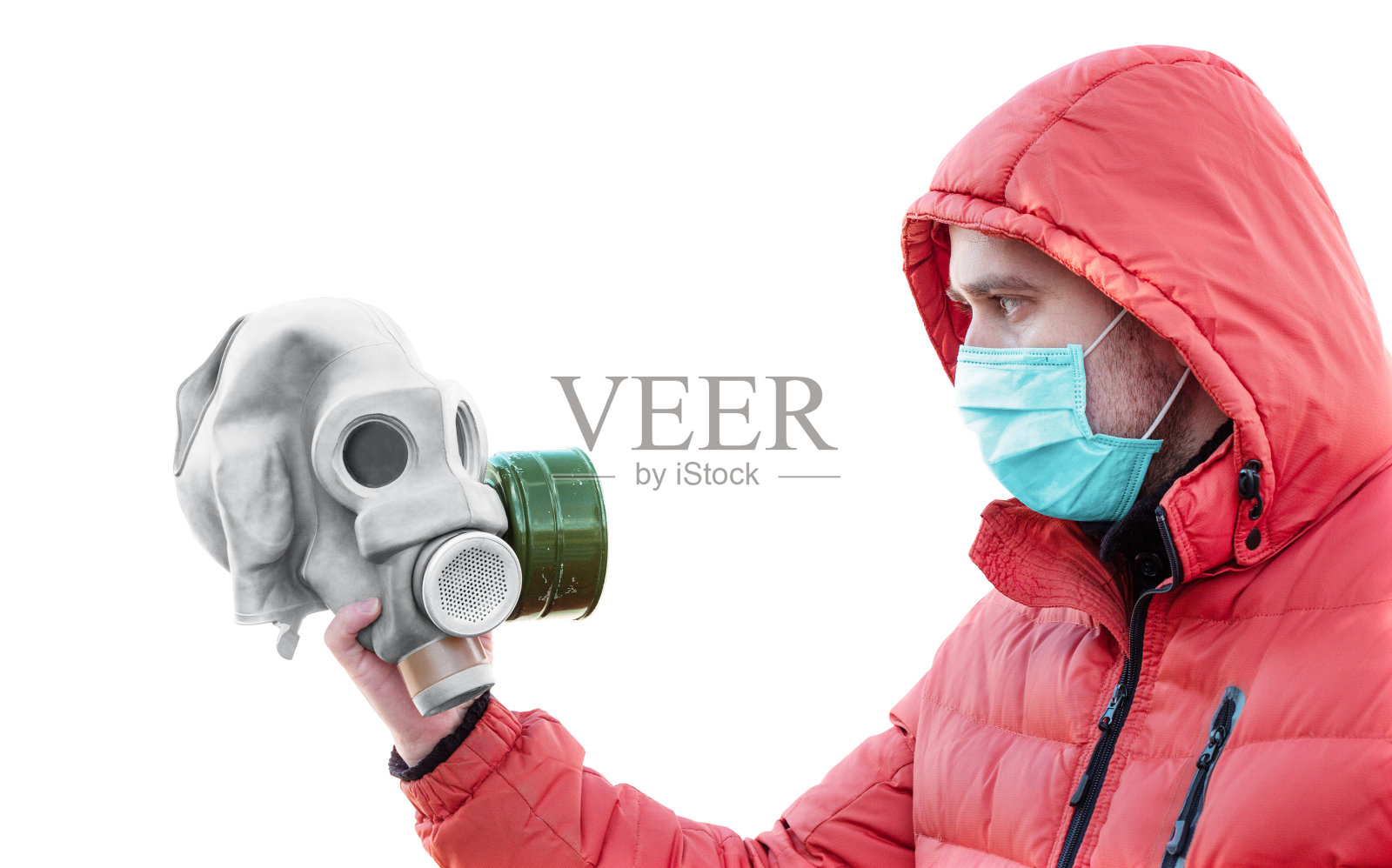 戴着医用口罩和兜帽的男子拿着防毒面具照片摄影图片