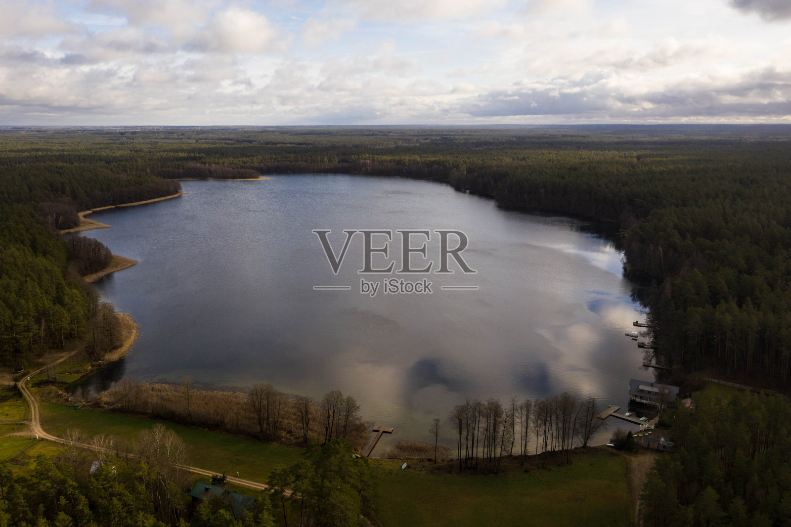 用无人机拍摄的湖边树林里的小木屋照片摄影图片