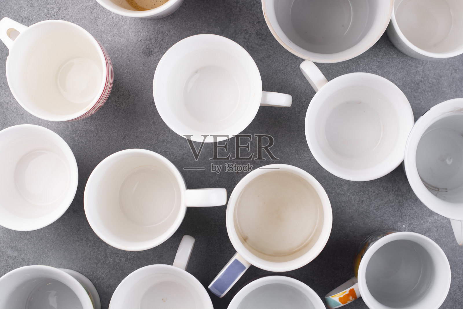 灰色的桌子上放着几个空杯子。吃完早餐菜肴。照片摄影图片