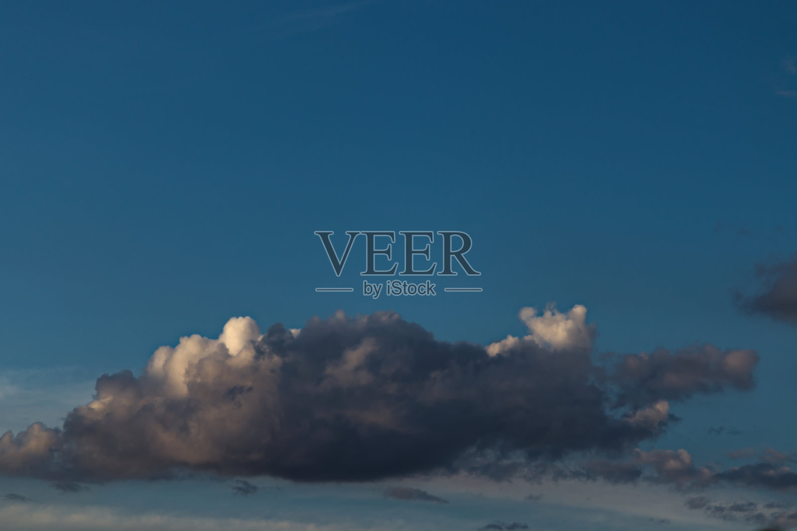 云的灰色阴影和阳光的边缘，漂浮在蓝天下孤立。照片摄影图片