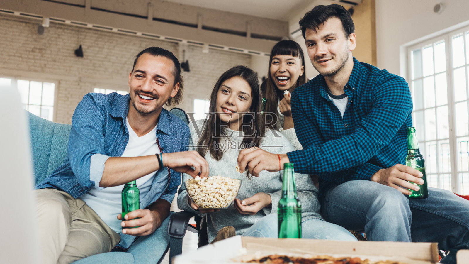 朋友家庭聚会：吃披萨、爆米花，享受假期照片摄影图片