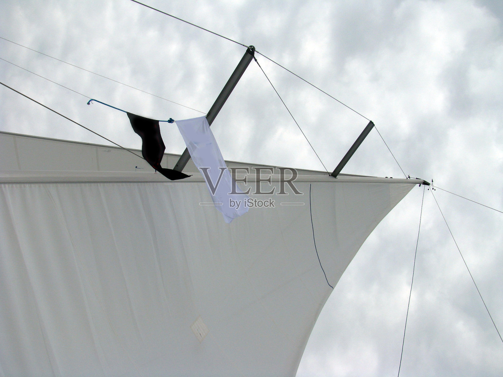 一种帆船的桅杆，帆和缆绳上挂着海盗旗照片摄影图片