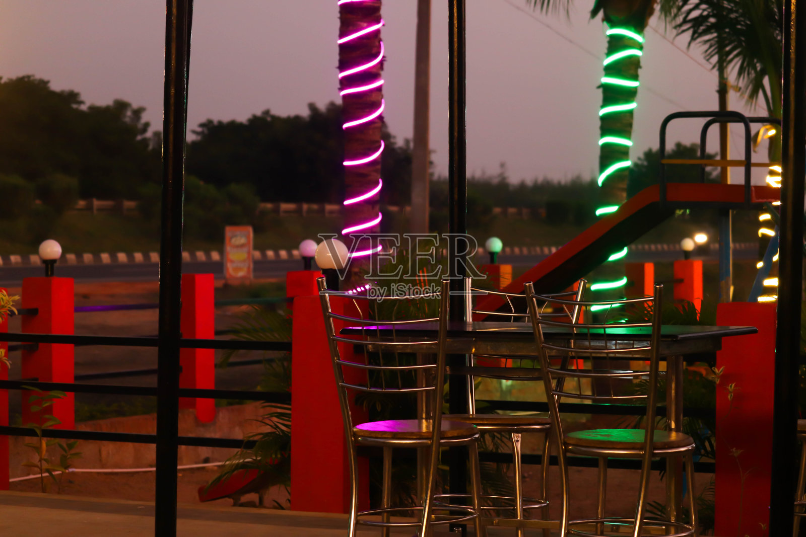 电影的外观花园餐厅酒吧与桌子和椅子在树上的彩灯在深夜照片摄影图片