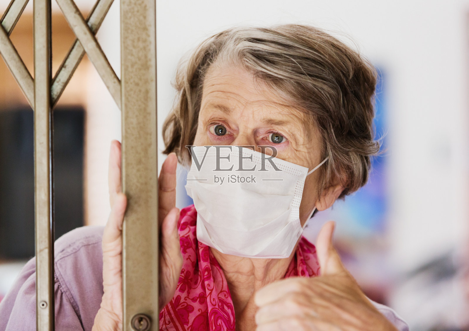 在COVID-19冠状病毒疫情期间，戴口罩避免感染的老年妇女照片摄影图片