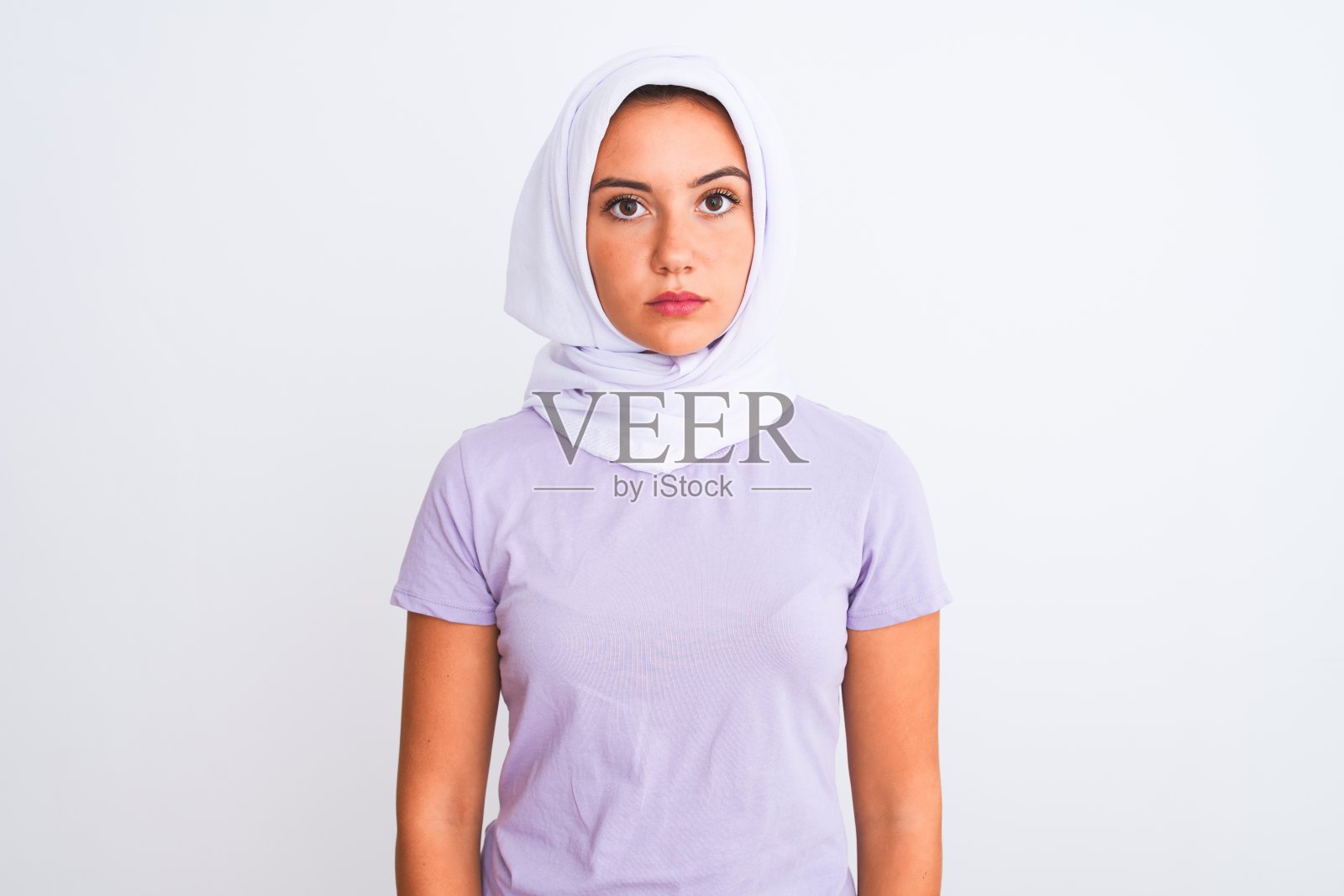 年轻美丽的阿拉伯女孩戴着头巾站在孤立的白色背景轻松与严肃的表情在脸上。简单自然的看相机。照片摄影图片